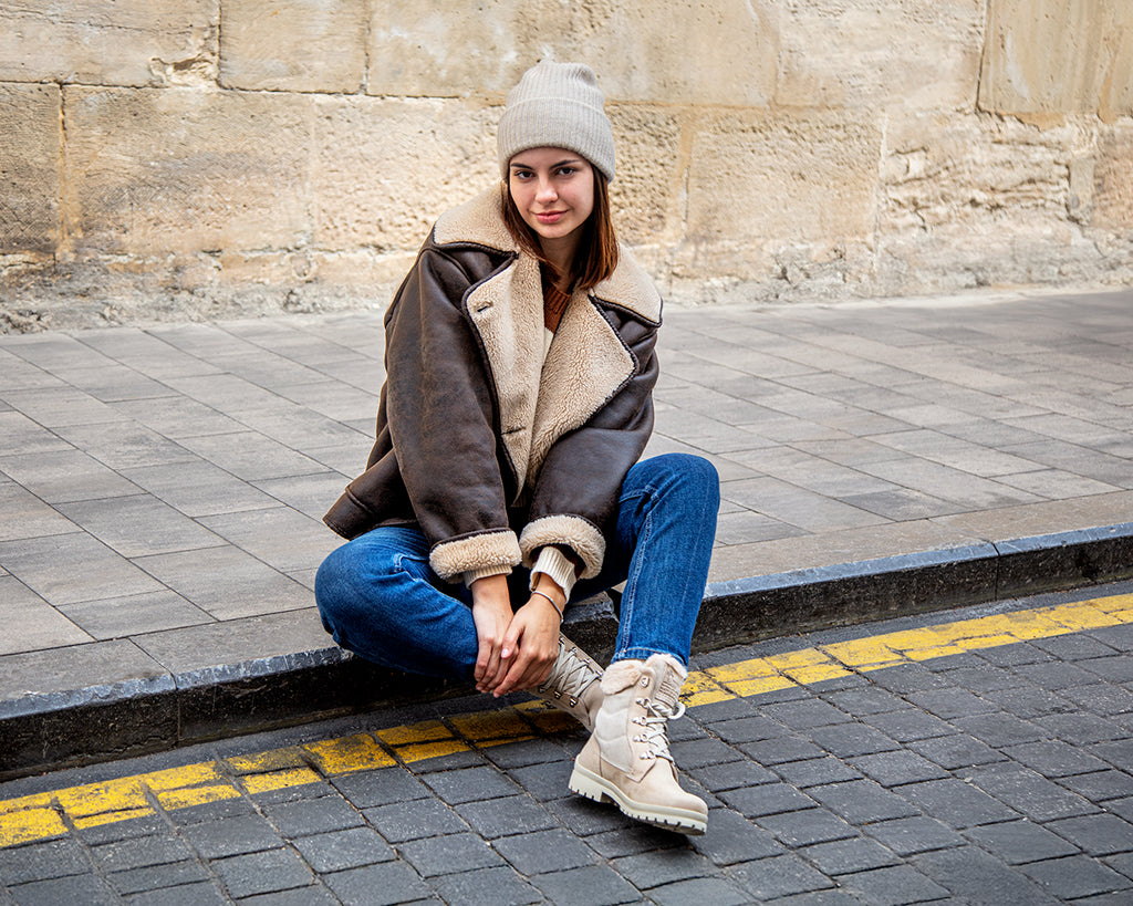 Chica sentada con botas de pelo Panama Jack